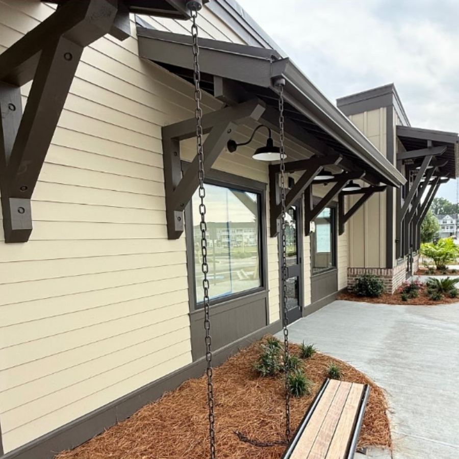 Modern dark bronze k-style gutters and decorative rain chains installed by Spartina Seamless Gutters on a commercial building in Georgetown, GA