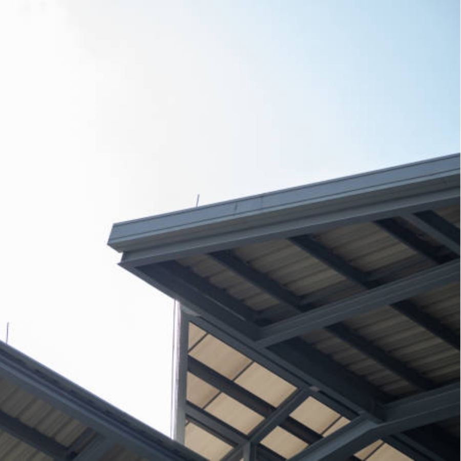Modern commercial structure in Greenville, SC with Spartina seamless gutters installed along the steel roof framing, highlighting clean lines and efficient rainwater drainage against a clear sky.